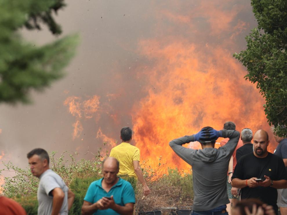 Vecinos de la localidad luchan contra las llamas del incendio.