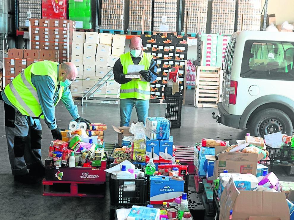 Voluntarios trabajan en la selección y reparto de lotes alimentarios.