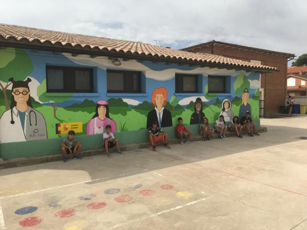 Escolares posan ante el mural recién inaugurado en el colegio de Fonz.