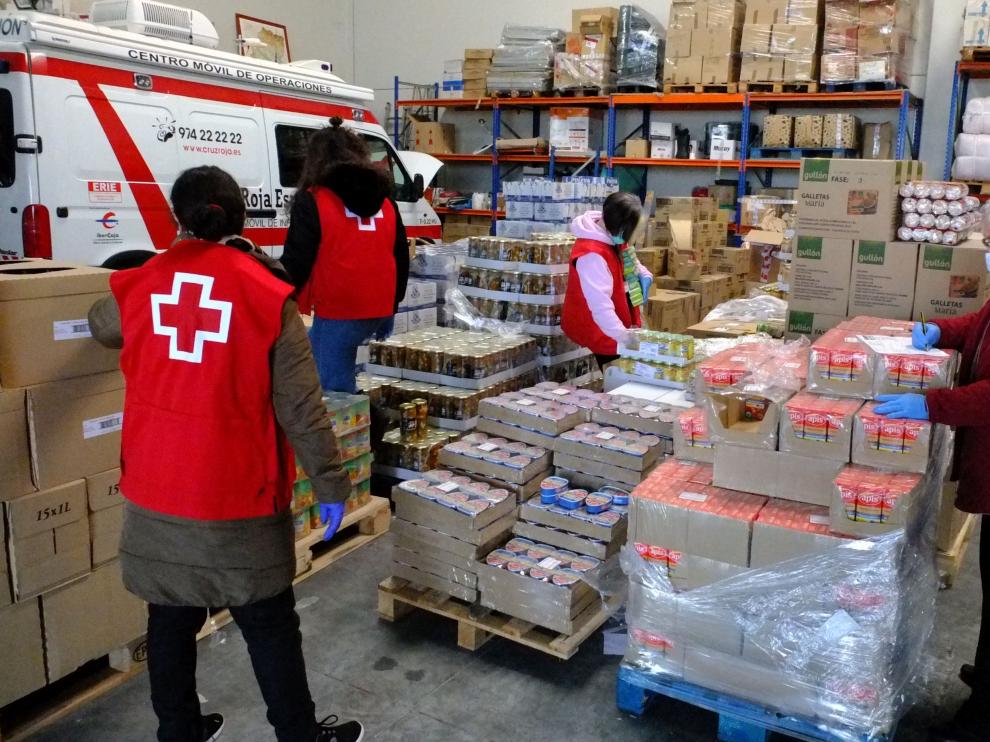 Voluntarios de Cruz Roja Huesca organizan alimentos para las 429 familias de la provincia que los disfrutarán.