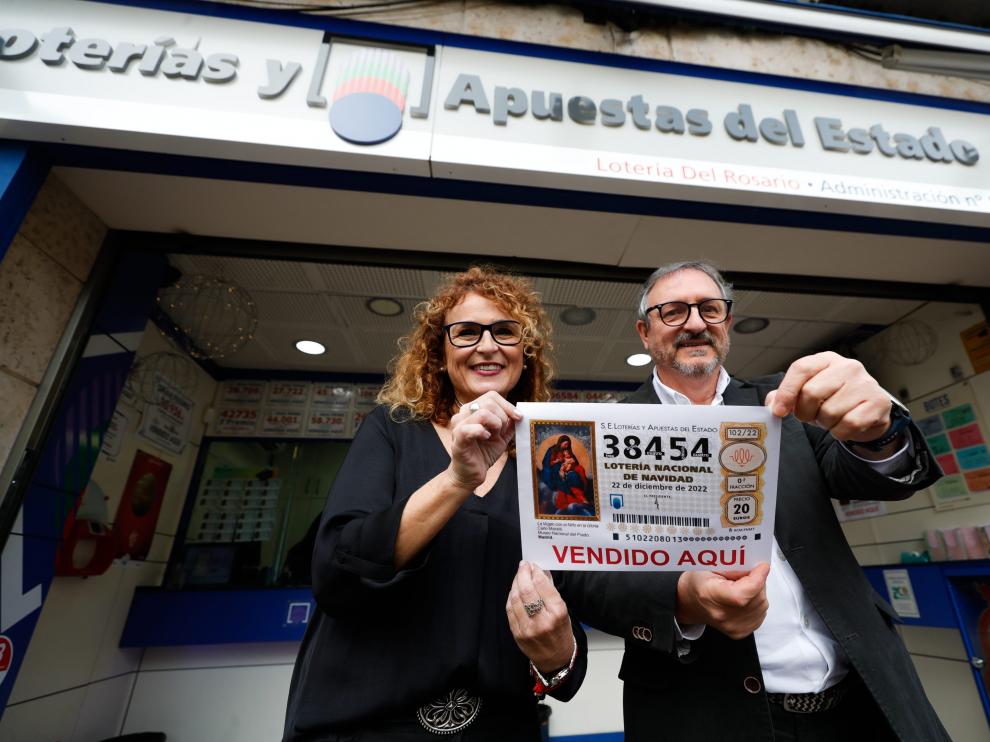 Los propietarios de la administración 'Lotería del Rosario' posan con una réplica del número 38454, uno de los quintos premios.