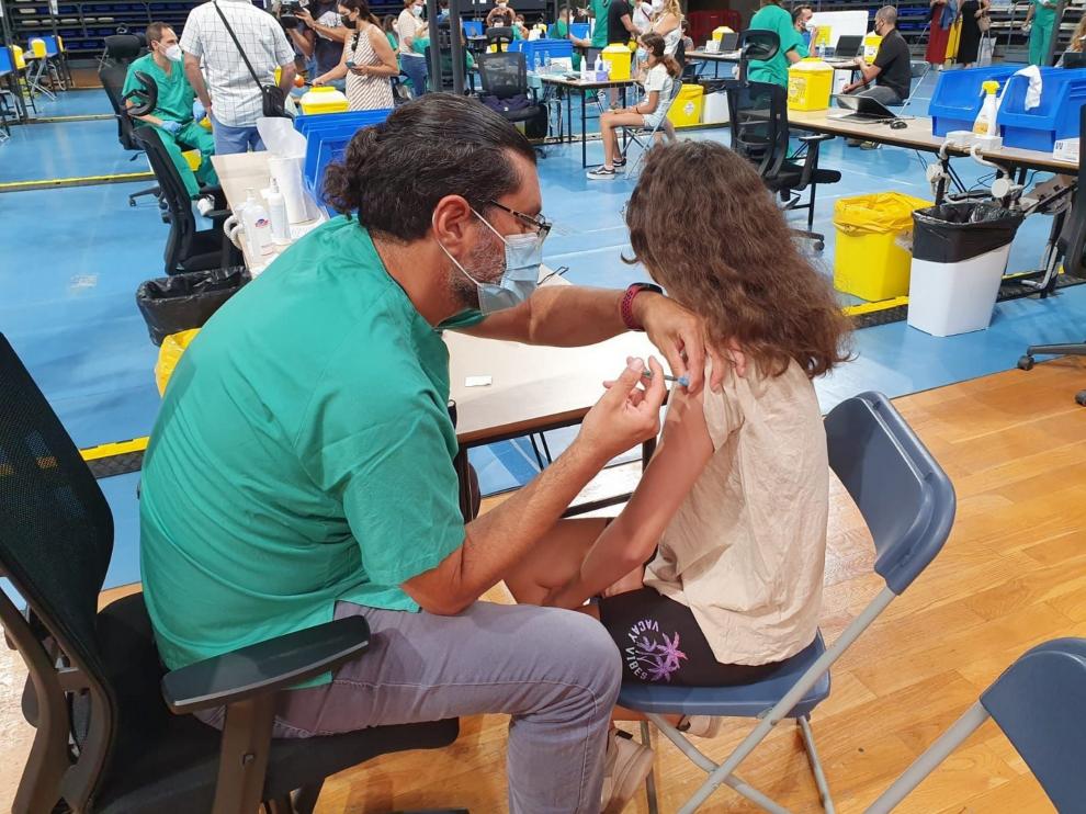 Un enfermero vacuna a una niña.