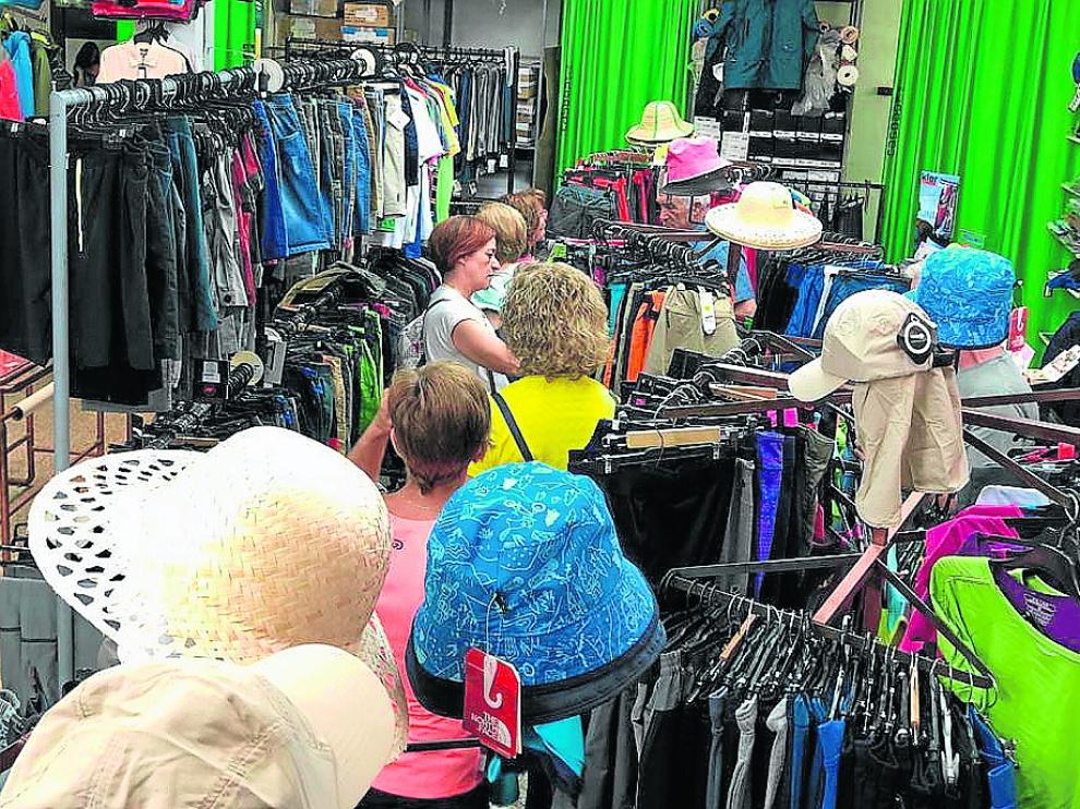 Varios clientes revisan la ropa disponible en el outlet de la empresa oscense Casbas enla población de Bolea.
