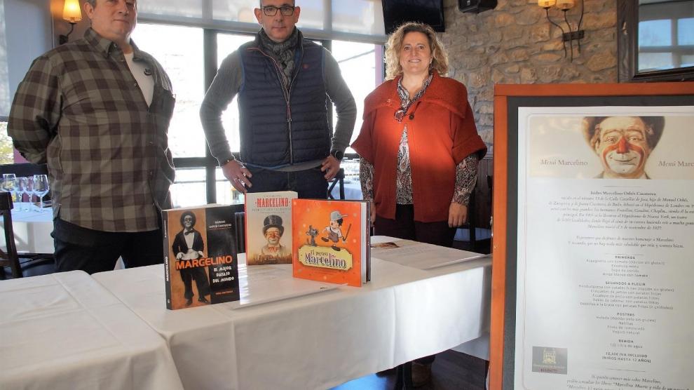 Fran Ponce, Francis Martín y Marian Bandrés junto al menú del restaurante Biarritz, donde se ha presentado esta iniciativa.