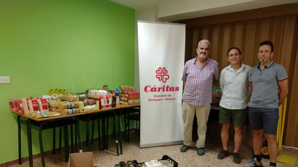 Fernando Latorre y Alejandro Castarlenas junto los alimentos donados a Cáritas.