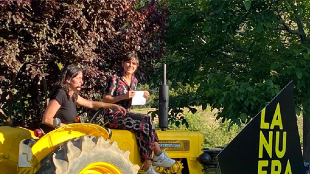 Elena S. Sánchez (derecha), subida al tractor que aparecía en el cartel, durante su inauguración.