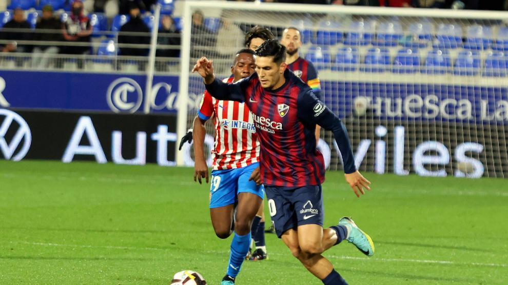 Cristian Salvador conduce el balón ante la presión de un jugador del Sporting.