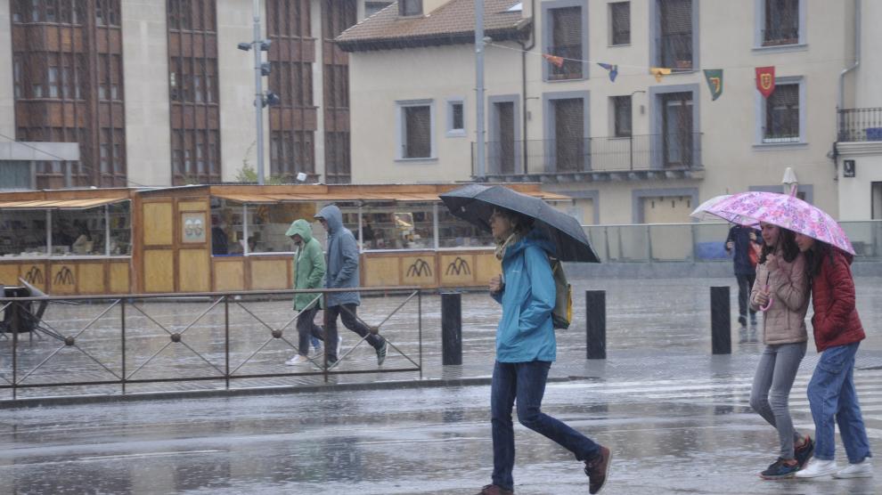 Vecinos de Jaca con paraguas esta sábado, por las calles de la localidad.