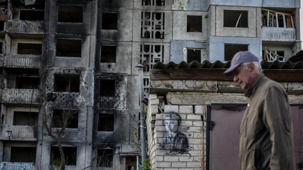 En la ciudad ucraniana de Borodyanka, un hombre pasa junto a una obra del artista Christian Guemy.