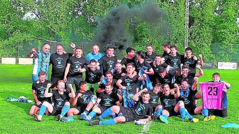 Jugadores y cuerpo técnico celebran sobre el césped el ascenso.