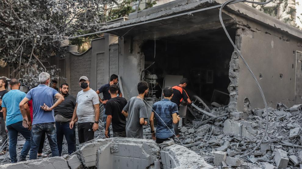 Un grupo de palestinos comprueban los destrozos sufridos tras un ataque israelí.