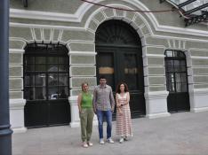 Asun Martínez, Fernando Sánchez y Marta Palomo (componente de la junta directiva de la Asociación Canfranc 1928), junto a la parte central del edificio de la Estación Internacional, cuyo exterior acogerá el acto principal de la recreación histórica.