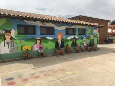 Escolares posan ante el mural recién inaugurado en el colegio de Fonz.