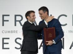 Macron y Sánchez se abrazaron ayer tras la firma del tratado.
